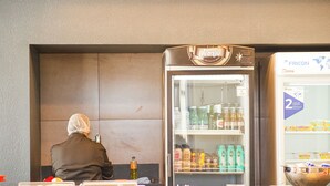 Een hotelkamer met een minibar, een koelkast en een buffet met diverse soorten eten.