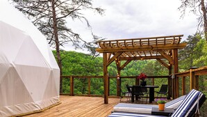 A wooden deck with a pergola, lounge chairs, a table, and a tent. - Spacious Glamping Dome - Canyon Views + Hot Tub - Tennessee Wilderness (Pikeville)