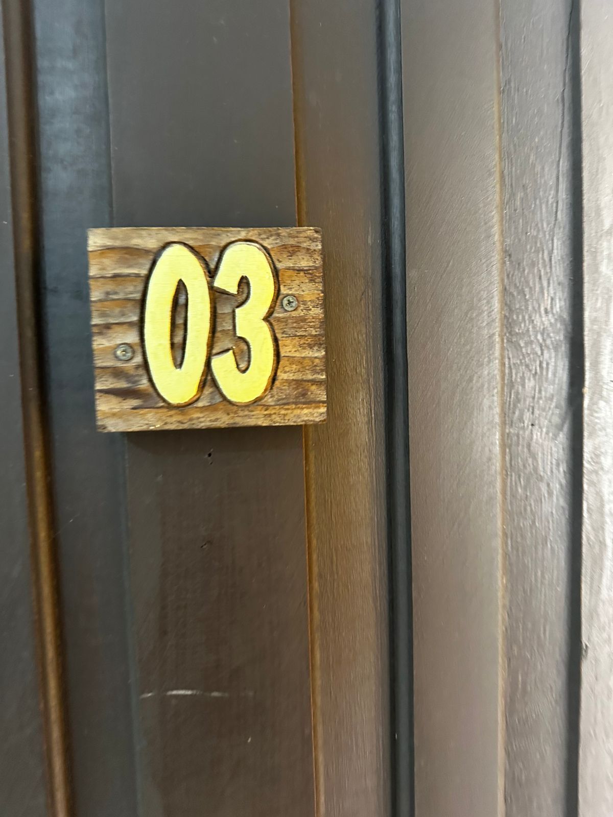 Een houten bordje met het nummer 03.