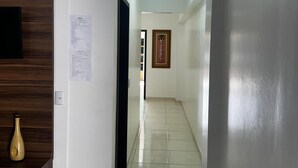 A hallway with a wooden panel wall, a framed artwork, and a tiled floor. - Residencial Vista Bela Apt 09 (Two Suites) (Centro Bombinhas)