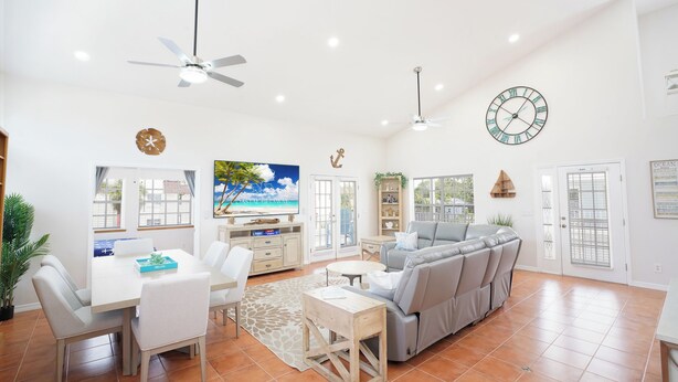 A spacious living area with a dining table, sofa, and ceiling fans. - Steps From Beach With 2 Golf Carts Sleeps 16! (Indian Rocks Beach)