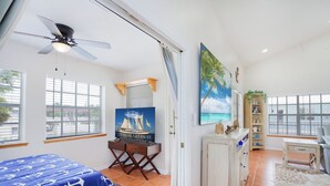 A room with a bed, a desk, a television, and a large window. - Steps From Beach With 2 Golf Carts Sleeps 16! (Indian Rocks Beach)