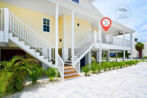 Un bâtiment à deux étages, à l’extérieur blanc, doté d’un porche et d’un escalier menant au deuxième étage.
