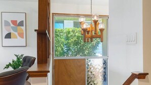 Eine moderne Treppe mit Holzgeländern und einer Glastür, die zu einem Raum mit Blick auf Grünfläche führt.