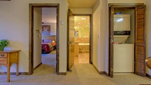 A hallway with a wooden desk, a mirror, and a door leading to a bathroom. - 1-Bedroom Condo w/ Fireplace in Sugar Mountain (Sugar Mountain)