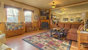 A cozy living room with a fireplace, a coffee table, and a patterned rug. - 1-Bedroom Condo w/ Fireplace in Sugar Mountain (Sugar Mountain)