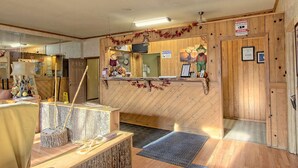 A reception area with a wooden counter, a 'Welcome' sign, and a 'Notice' sign.