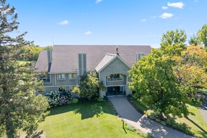 A two-story building with a sloped roof, a front entrance, and a driveway leading to the main entrance.