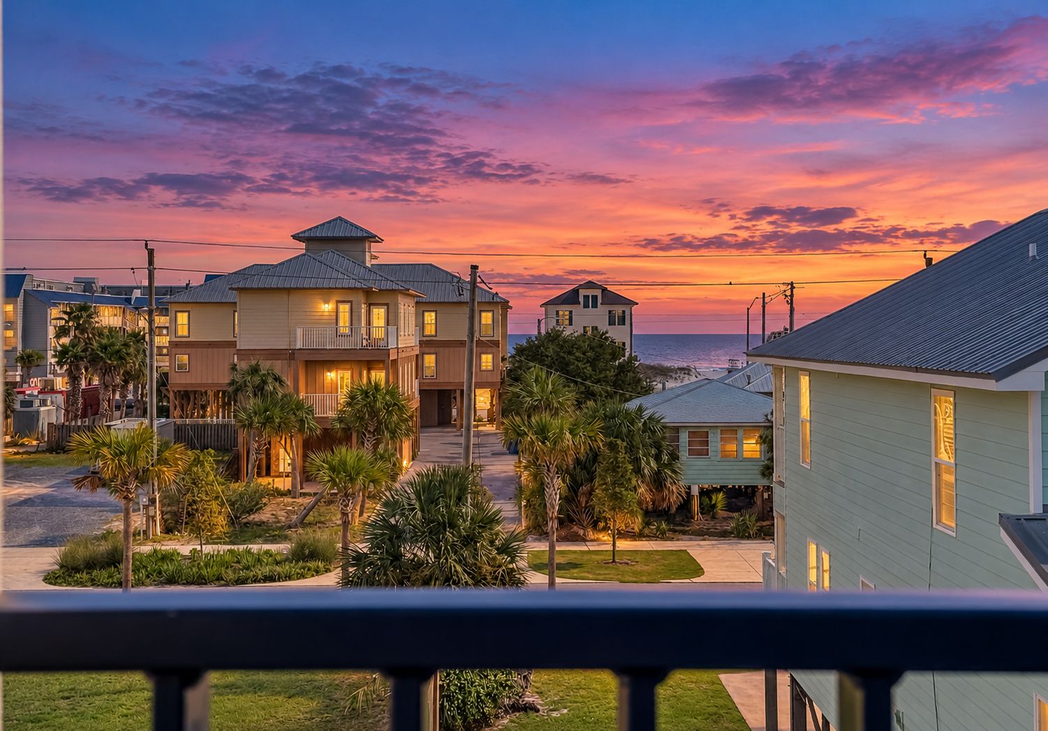 A residential area with multiple houses, a clear sky, and a sunset.