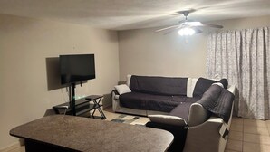 A living room with a flat-screen TV, a ceiling fan, a sofa, and a coffee table. - 2-bedroom house in delightful Lajas with AC (Lajas)
