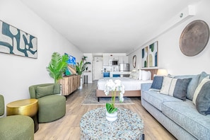 A modern living room with a sofa, a round coffee table, and a TV.