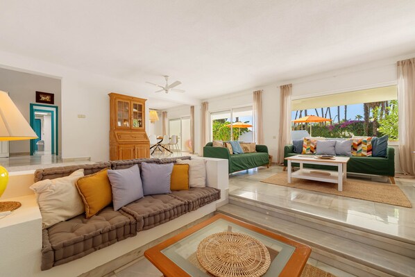 A spacious living room with a sofa, a coffee table, and a view of the outdoors.