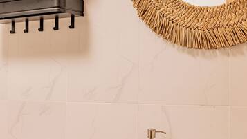 Ein Badezimmer mit Toilette, Waschbecken mit Spiegel und Handtuchhalter mit Handtüchern.