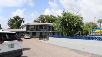 A building with a flat roof, large windows, and a blue decorative fence.