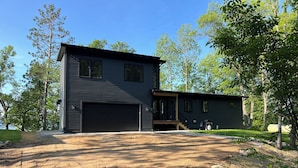 A two-story house with a garage and a covered porch.