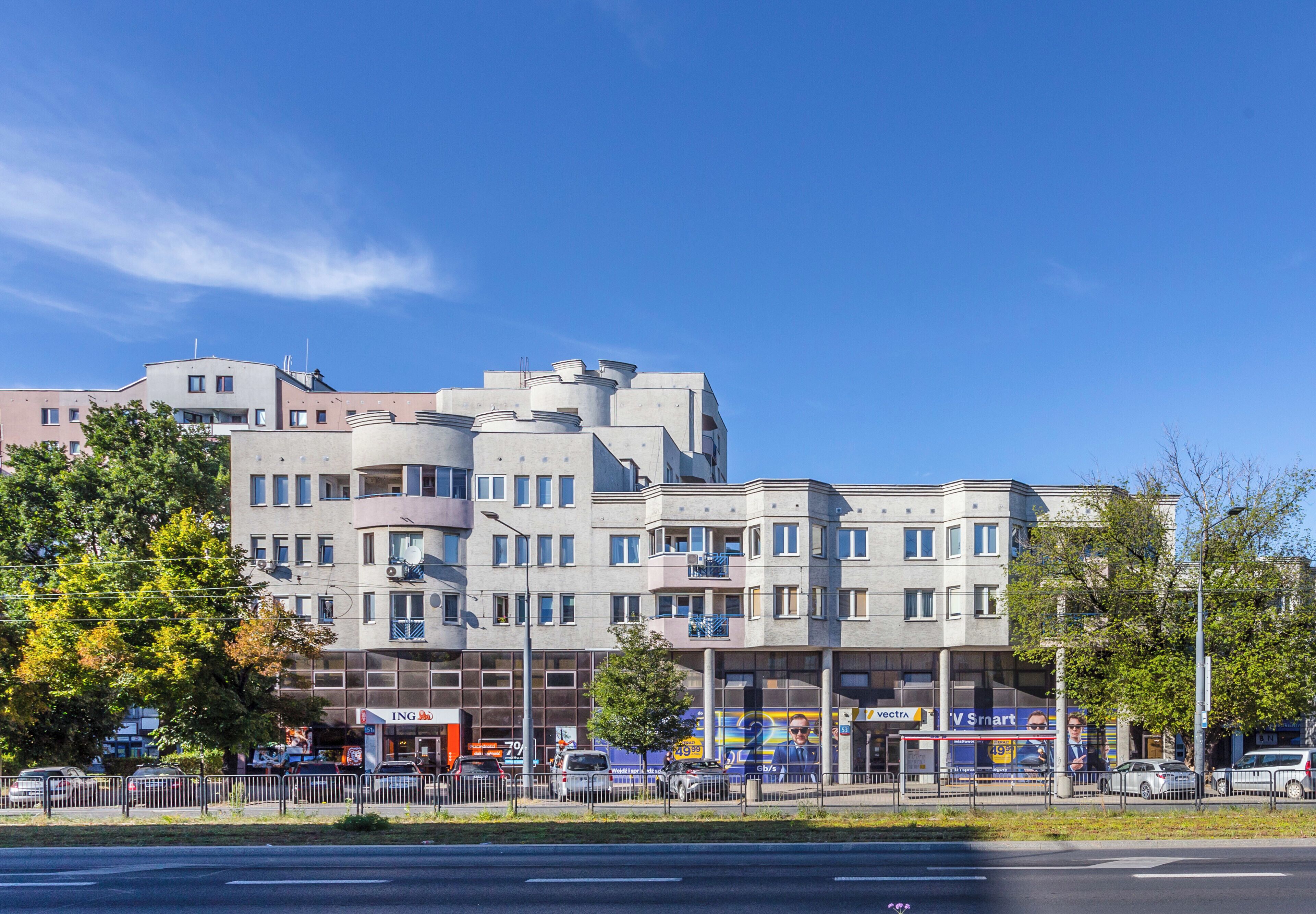 A multi-story building with a modern architectural design, featuring a mix of balconies and large windows.