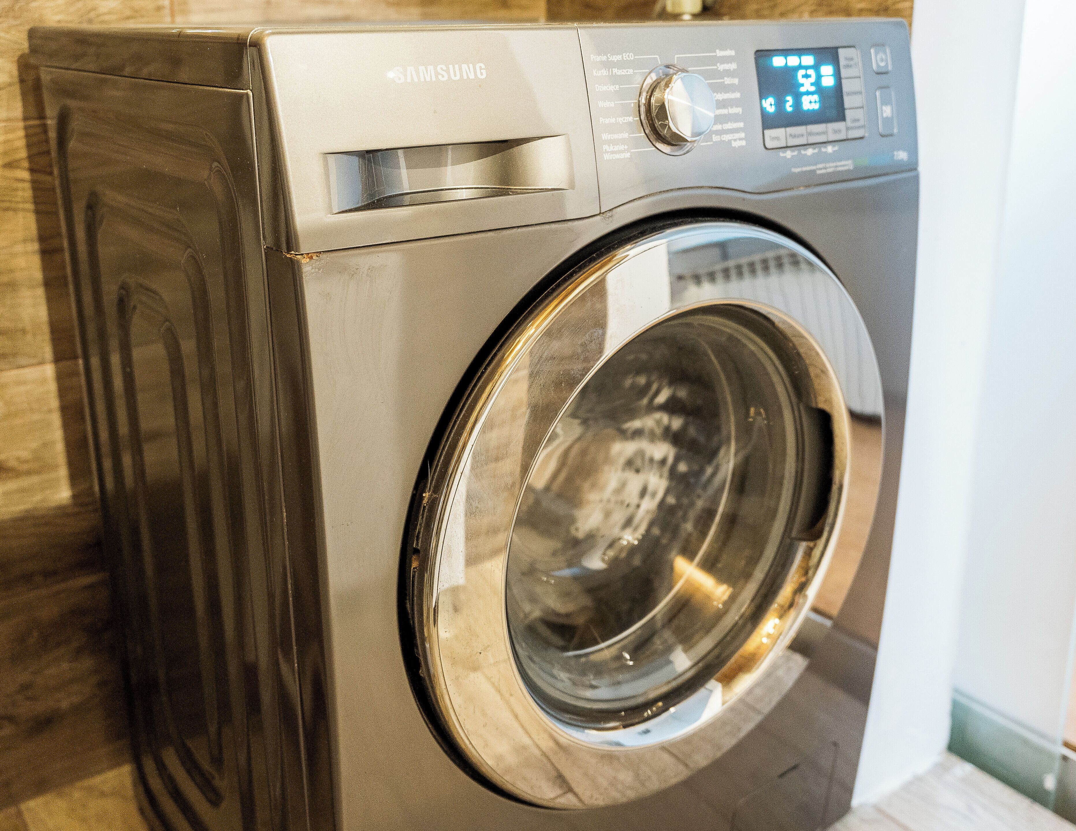 A Samsung front-loading washing machine with a digital display and control panel.