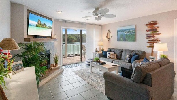 A modern living room with a television, sofa, coffee table, and plants.