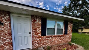 A single-story house with a white door and brick exterior. - Drew’s Delight - Relax in Comfort!  Modern, Fully Remodeled, No Stairs! (Mountain Grove)