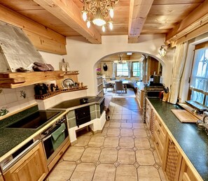 A kitchen with a central island, wooden cabinets, and a tiled floor.