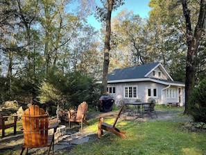 A house with a covered patio area, outdoor seating, and a grill. - Woodside Cabin in Delaware Water Gap (Dingmans Ferry)