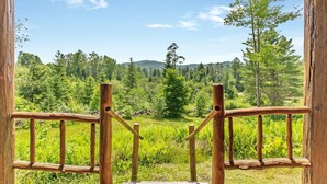 A wooden balcony with a view of a forested landscape. - Mountain View Log Cabin in the White Mountains (Dalton)