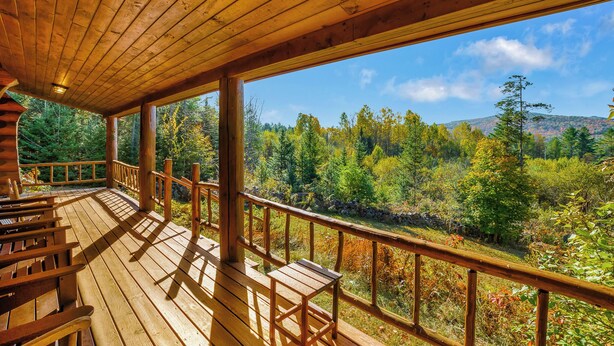 A wooden deck with benches overlooking a forested valley. - Mountain View Log Cabin in the White Mountains (Dalton)