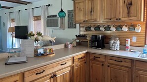 A kitchen with wooden cabinets, a coffee maker, and a jar of sugar. - Port Clinton Lakeside Escape (Erie Township)