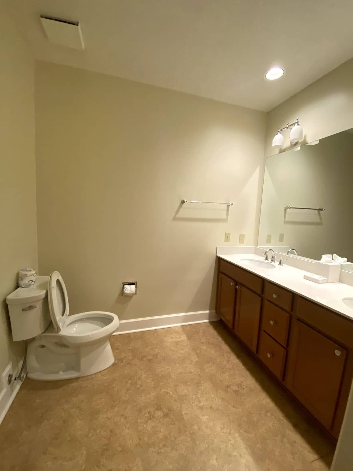 Une salle de bain avec des toilettes, un lavabo et un miroir.