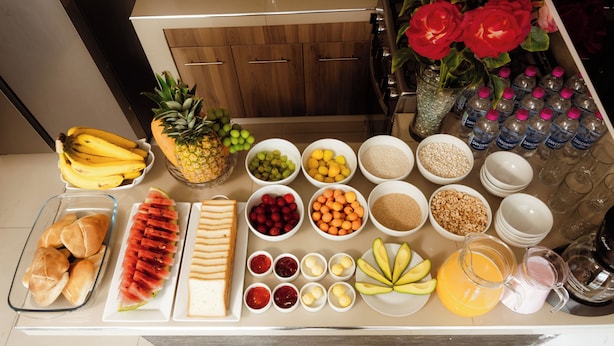 Uma bancada de cozinha com várias frutas, legumes e temperos.