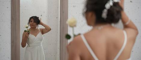 Una persona con un vestido blanco parada frente a un espejo.