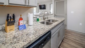 A kitchen with granite countertops, stainless steel appliances, and a flat-screen TV mounted above the sink. - 3 mins from Space Center &BridgeStreet. (Huntsville)