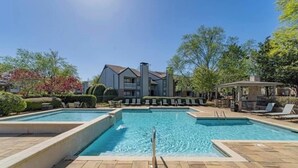 A rectangular swimming pool with a clear blue water surface, surrounded by a tiled deck. There are lounge chairs and a gazebo in the background. - 3 mins from Space Center &BridgeStreet. (Huntsville)
