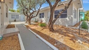 A modern two-story house with a covered patio, a driveway, and a well-maintained lawn. - 2 Studios for 6 | Near Dania and Hollywood Beach (Hollywood)