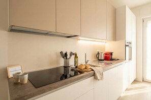 A modern kitchen with a built-in stove, a sink, and a coffee machine. - Borgo Felice 5 (Cozy Apartment with Balcony) (Bari)