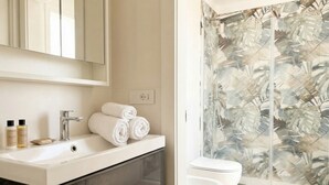 A bathroom with a white sink, a mirror, and a shower with a leaf-patterned glass door. - Borgo Felice 5 (Cozy Apartment with Balcony) (Bari)