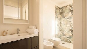 A modern bathroom with a large mirror, a sink, a toilet, and a bidet. - Borgo Felice 5 (Cozy Apartment with Balcony) (Bari)