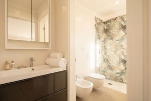 A modern bathroom with a large mirror, a sink, a toilet, and a bidet. - Borgo Felice 5 (Cozy Apartment with Balcony) (Bari)