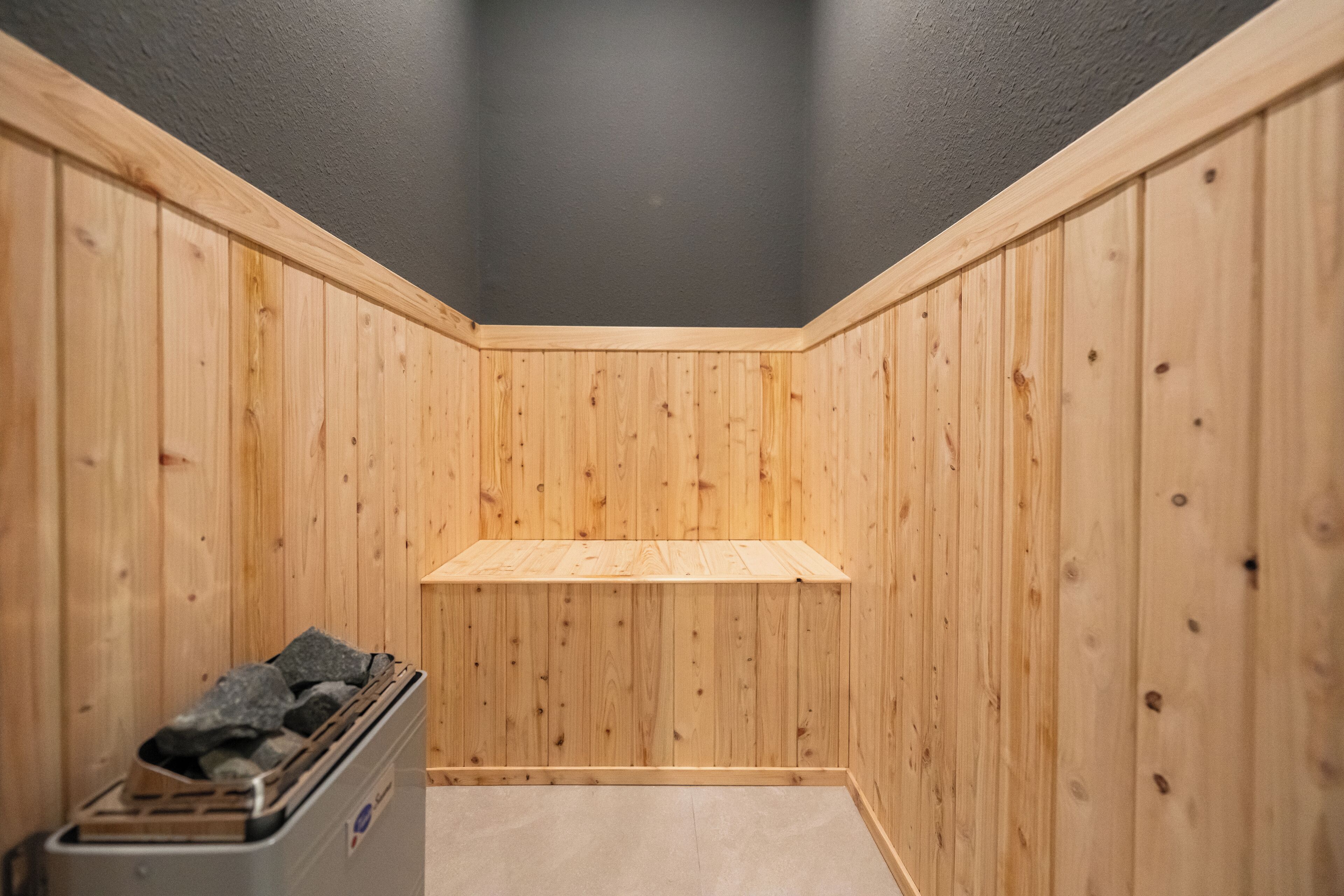 Een hoek van een kamer met houten wanden en een grijze plafond.