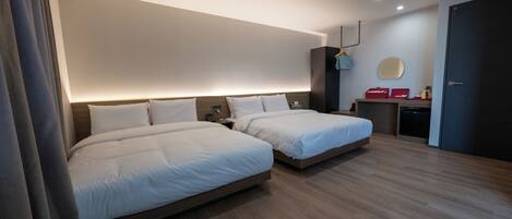 Una habitación de hotel moderna con dos camas, un escritorio, un espejo y un armario.