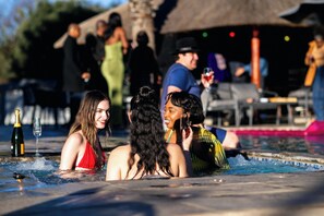 A pool area with people relaxing and socializing.
