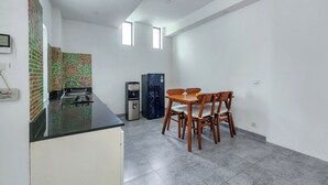 Una cocina compacta con refrigerador, cafetera y salpicadero de azulejos.