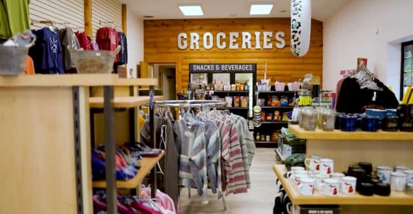 Ein Lebensmittelgeschäft im Inneren, mit einem Schild für 'Groceries' und 'Snacks & Beverages'.