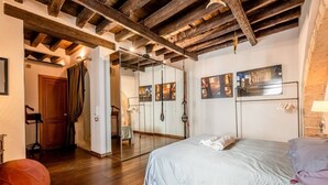 A bedroom with a wooden ceiling, a bed, a mirror, and artwork on the wall. - Emma  Art & Wine - Historic Townhouse (Bari)