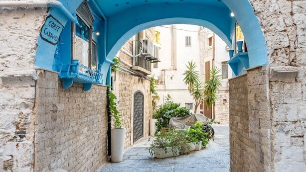 An alleyway with a blue archway, a sign reading 'Corte Carducci,' and potted plants. - Emma  Art & Wine - Historic Townhouse (Bari)