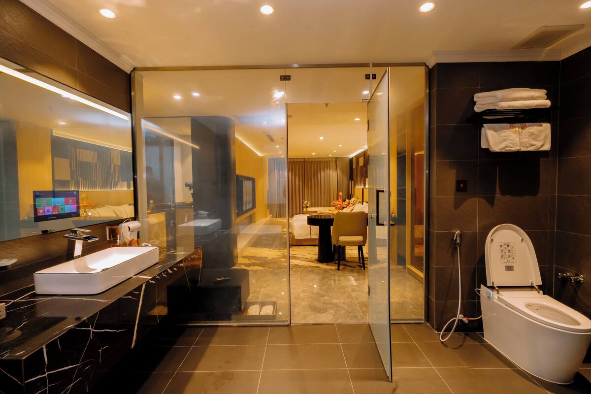 A modern bathroom with a glass shower enclosure, a white sink, and a toilet.