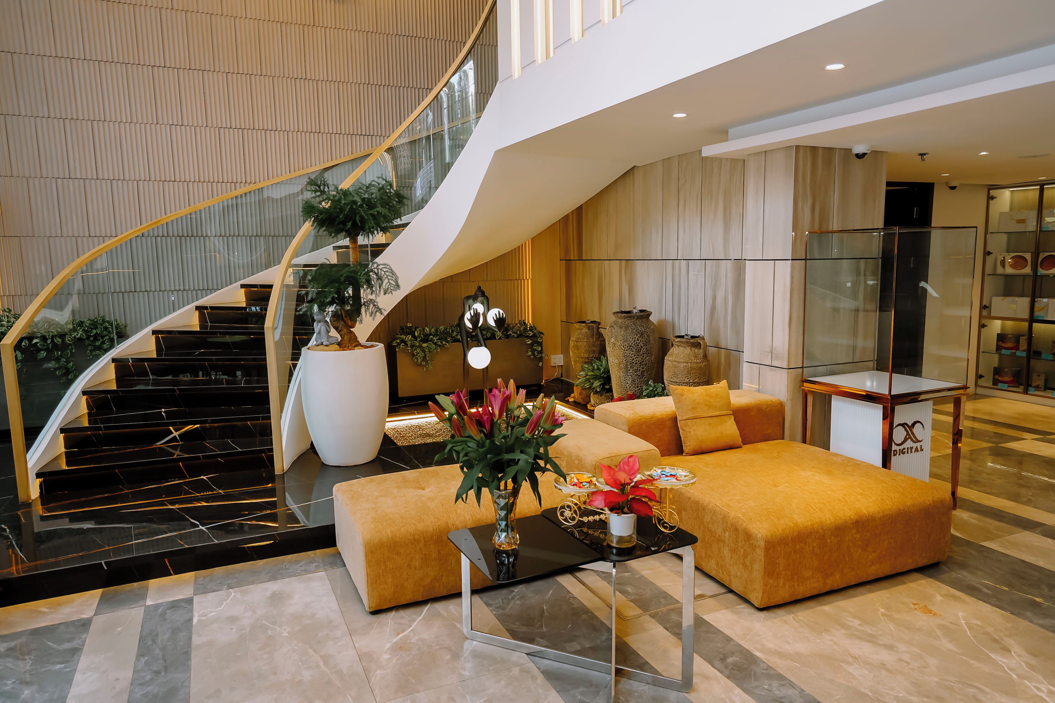 Un intérieur moderne avec un escalier à volutes, des sièges confortables et des plantes décoratives.
