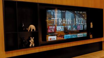 Una pantalla de televisión mostrando la interfaz de un servicio de transmisión con la frase 'TRAIN JAZZ' destacada.