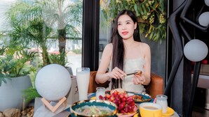 A dining area with a table set for a meal, including a bowl of fruit, a glass of milk, and a cup. - X-Digital Hotel (Kinh Bac)