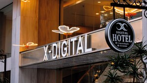 The exterior of the X-DIGITAL Hotel with a modern design, including a prominent sign and decorative lighting. - X-Digital Hotel (Kinh Bac)